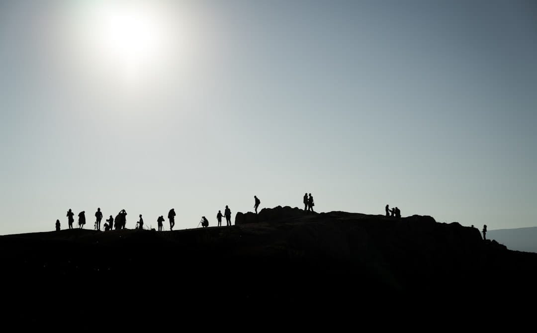 Photo by Patrick Schneider silhouette of people on mountain