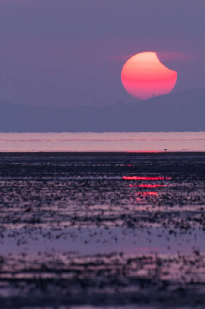 Éclipse au coucher du soleil inclue dans le paysage